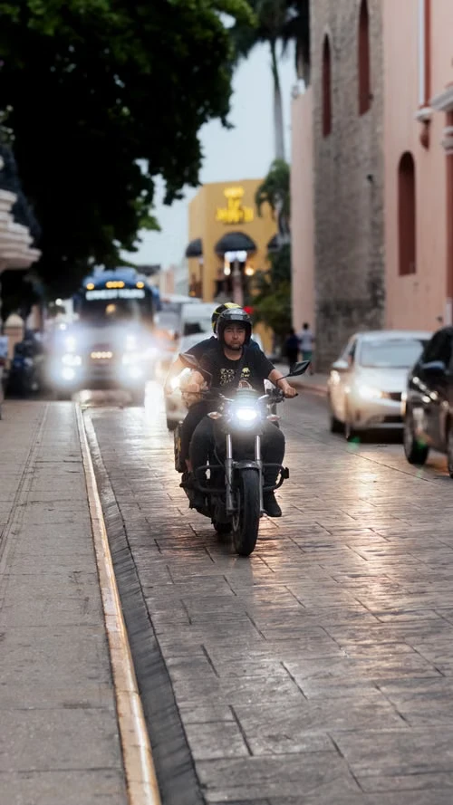 Motorizado rodando por la ciudad al atardecer