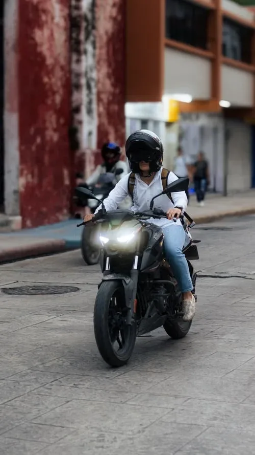 Motorizada con casco en la ciudad